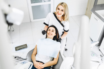 Obraz premium Pretty young female dentist making examination and treatment for young female patient in dental clinic.