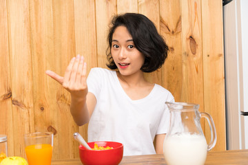 Asian young woman having breakfast milk inviting to come