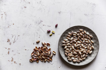Salted pistachios on a gray plate