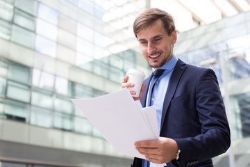 Professional man in jacket walking with coffee