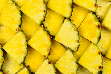 Pineapple juicy yellow slices background. Top view.