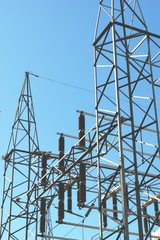 High voltage electrical insulators at a power station. Low angle shot against a blue sky.