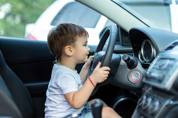 Little boy play with steering wheel in  car