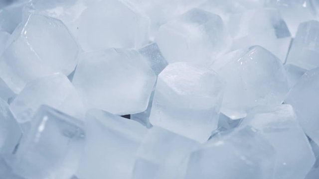 Macro shot of ice cubes from clear water that melt in slow motion on a white background. Concept: pure mountain spring water, ice, cocktails, fresh and frozen foods.