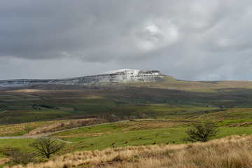 View to a snow covered Whernside across farmland