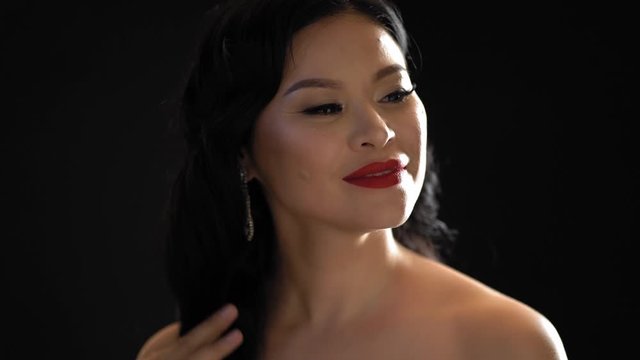 Adult Asian Lady With Makeup Tourch Her Hair In Studio