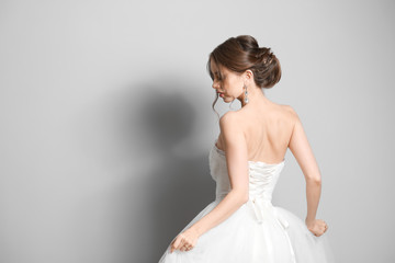 Beautiful young bride on grey background