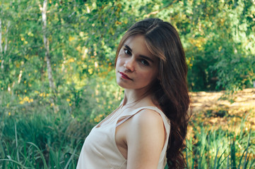 portrait of an attractive young woman, a girl who is enjoying the sunset on the street in the Park in the background.