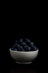 a bowl of blueberry isolated on black background