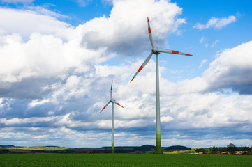 Fototapeta premium wind turbines in the field against cloudy sky