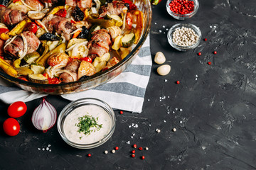 Meat with vegetables. Healthy baked food. Close-up. Zucchini, peppers, tomatoes, apples. Garlic Sause. Top view