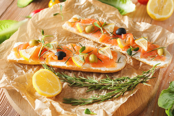 Tasty sandwiches with salmon on parchment