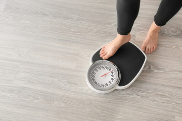 Woman with scales at home. Weight loss concept
