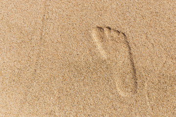 Fototapeta na wymiar Right foot print in yellow sand. top view.