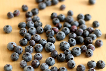 Pile of blueberries on a wooden table. Selective focus.