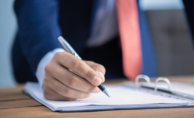 businessman signs documents in his office
