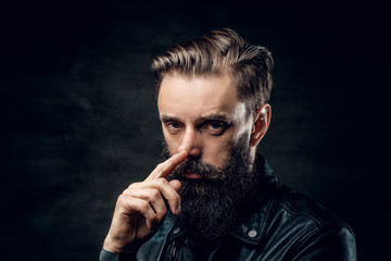 Portrait of hopeless bearded man with hairstyle on the black background.