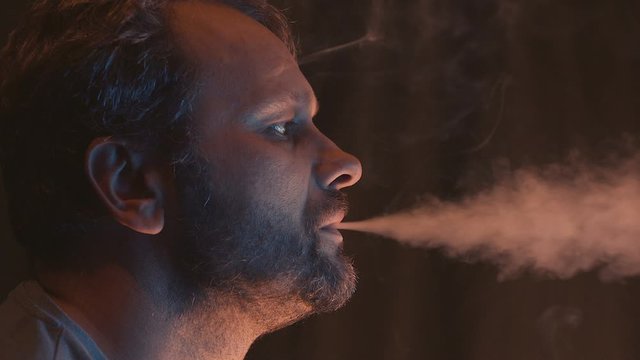 Full Head Face Young Man Smoking indoor cigarette smog with nicotine, .  Close-Up,Toxic smoke concept. Slow motion 50p