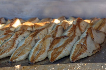 Cut and cleaned and fried fish on grill counter.