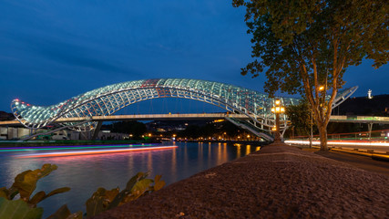 Fototapeta na wymiar Bridge of peace in Tbilisi city centre during evening blue hour