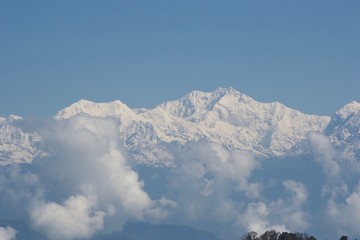 clear blue sky and snowy mountains in fog