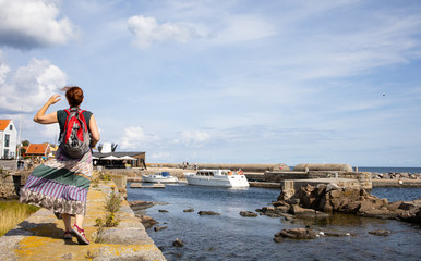 View of the port of Svaneke, Female tourist in colorful dress, Bornholm