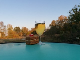glass of beer on the background of blue sky and white clouds