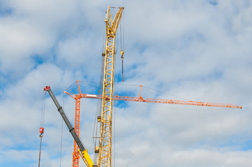  Different construction cranes on a background of blue sky. Equipment for the construction of buildings.