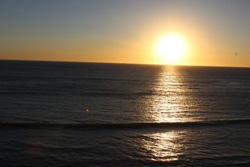 sea ​​scene with sun hiding on the horizon at sunset