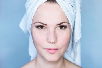 Natural, natural beauty of a woman. Girl with a towel on her head after the procedure. Care for the radiant skin of the face and fresh skin of the girl. Beautiful, radiant face, close-up.