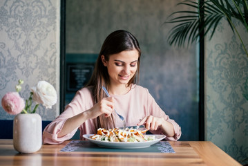 Charming young woman having delicious lunch alone at a nice restaurant.
