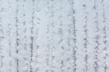 Snow surface with ice texture close-up. Abstract background with snow stripes. The basis for the layout or site.