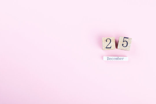 Wooden block calendar 25th December on a pink background. Happy Christmas holiday celebration concept, Copy space your text - Powered by Adobe