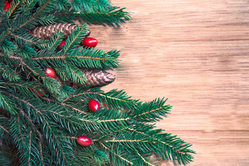 Creative arrangement of Christmas pine branches on a on wood-colored background