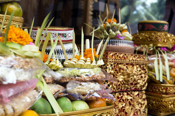 Traditional offerings to gods in Indonesia with flowers, fruits and aromatic sticks in temple, buddhist