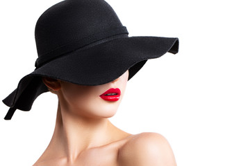 girl in a black hat posing in the Studio. red lips. the hat covers part of the face
