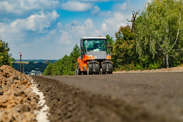 Road roller at road construction site. Construction and repair of highway.