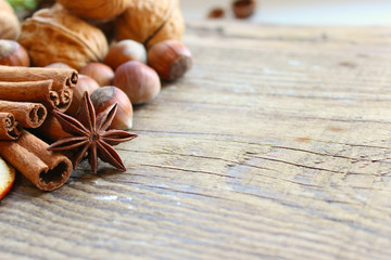 Top border of festive spices and baking ingredients on rustic wooden background. Christmas, New year background. Copy space.
