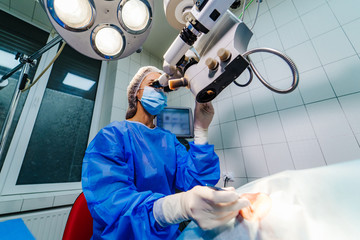 Eye surgery. A patient and surgeon in the operating room during ophthalmic surgery. Patient under...