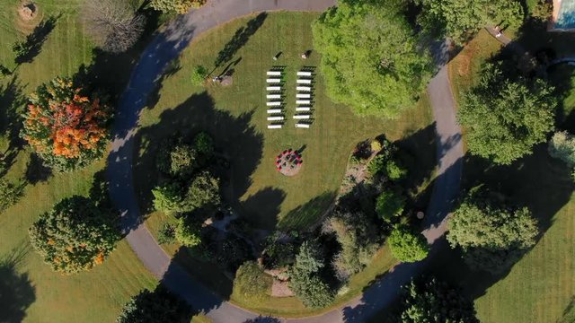 Ascending Aerial: White Tables Set Up in a Green Field Surrounded By Trees and Picturesque Buildings - Boyce, Virginia