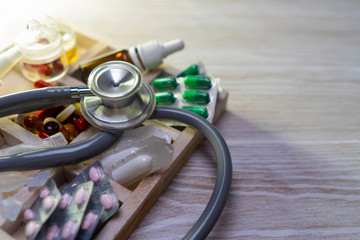 a variety of medicines in a wooden box with dividers on the table, local focus