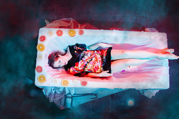 Young woman relaxing in Spa bath with slices of oranges. Welness concept.