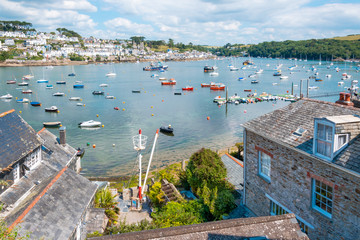 View of beautiful Cornish harbour town Fowey and boats moored in Fowey Estuary from Polruan, South Cornwall, UK - obrazy, fototapety, plakaty