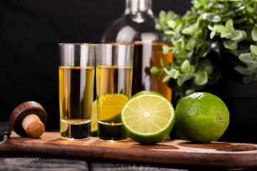 Mexican Gold Tequila with lime and salt on black background with copyspace.