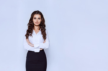 Portrait of young modern business woman in classic suit. Attractive female business leader in smart casual wear with crossed arms. Office worker.