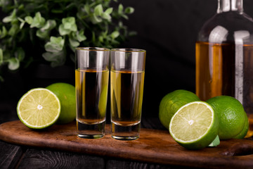 Mexican Gold Tequila with lime and salt on black background with copyspace.