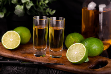 Mexican Gold Tequila with lime and salt on black background with copyspace.