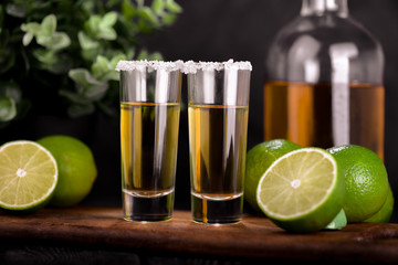 Mexican Gold Tequila with lime and salt on black background with copyspace.