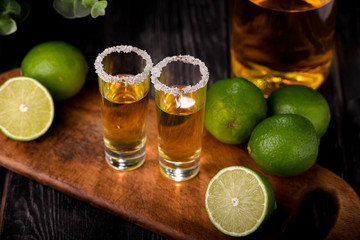 Mexican Gold Tequila with lime and salt on black background with copyspace.