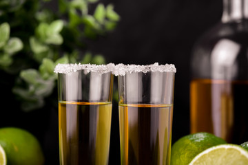 Mexican Gold Tequila with lime and salt on black background with copyspace.